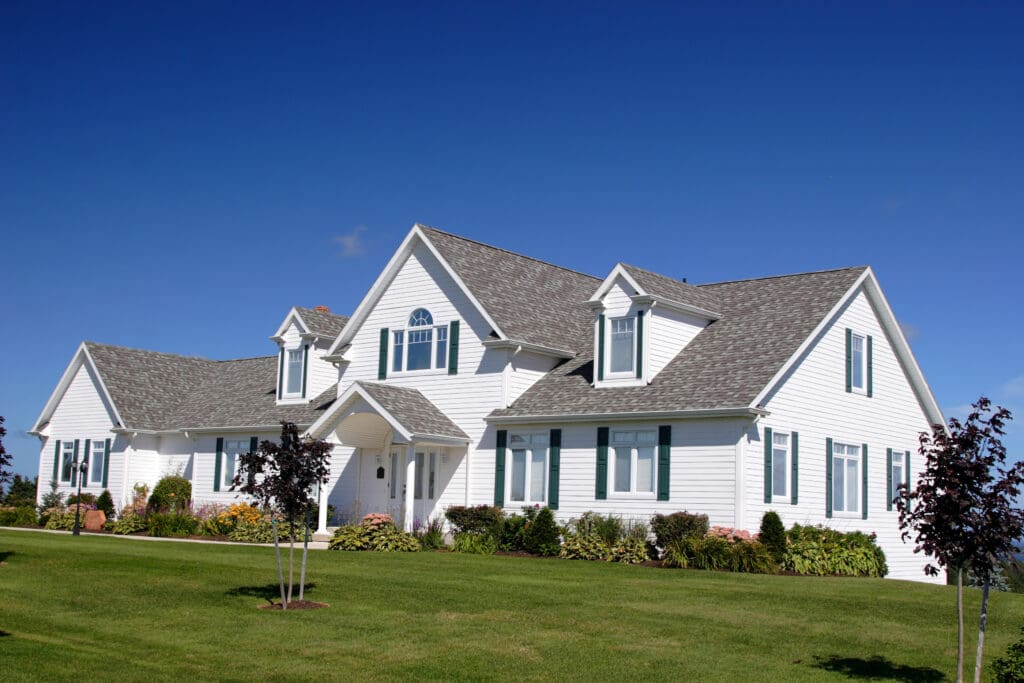 An upscale executive home surrounded by a lush green lawn
