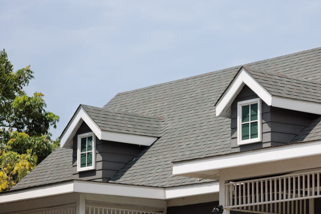 Roof shingles with garret house on top of the house. dark asphal